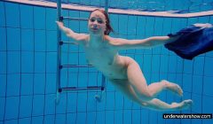 Teen girl Avenna is swimming in the pool